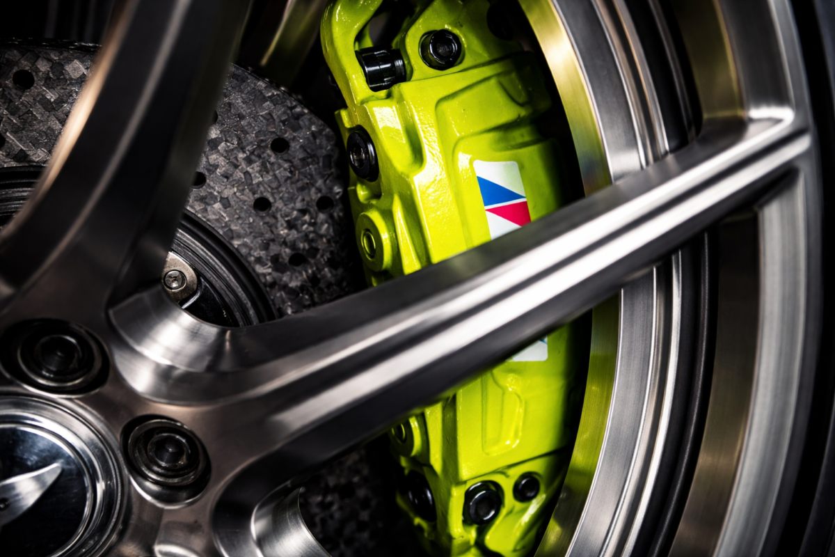 Close-up of a massive Big Brake Kit (BBK) perfectly clearing the backpad of a custom forged wheel, highlighting precise ET and X-factor engineering.