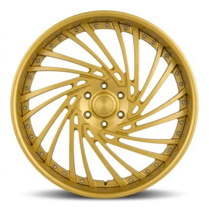 Front-facing commercial product shot of a custom 24x12 3-piece forged wheel for Ram 1500, featuring a dynamic directional multi-spoke design and a brilliant vacuum electroplated gold finish.